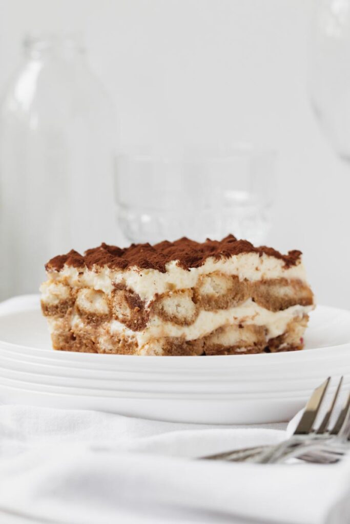 beautiful clean white environment with a classic italian tiramisu, showing each layer clearly